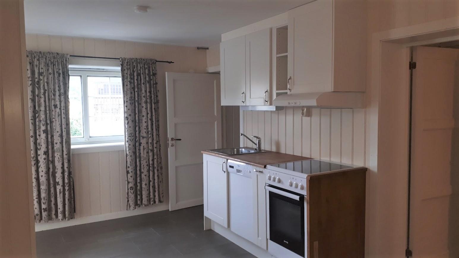 Kjøkken med komfyr og oppvaskmaskin